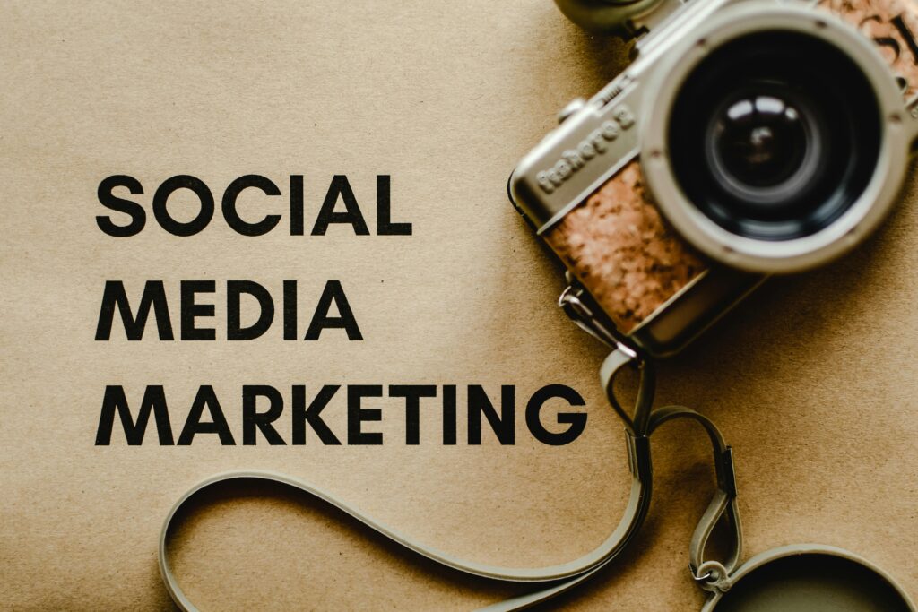 Ocena kampanii reklamowej w social media – napis „Social Media Marketing” oraz aparat fotograficzny, strategia marketingowa online